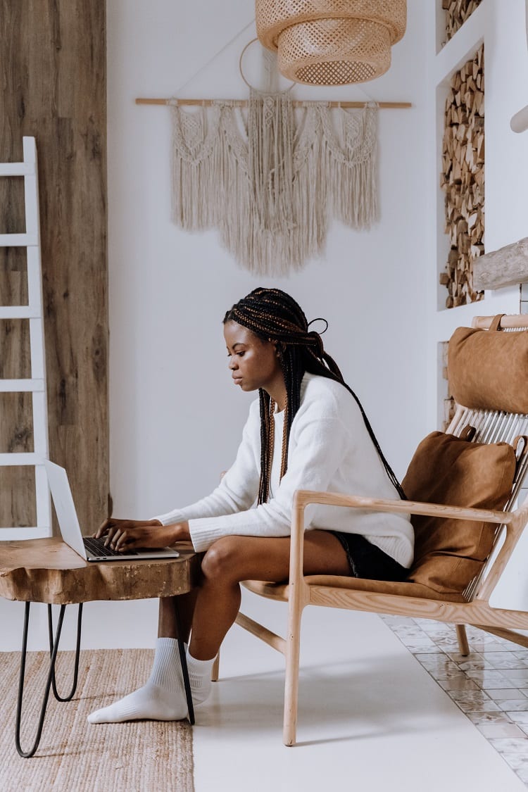 mulher sentada em poltrona fazendo aula online