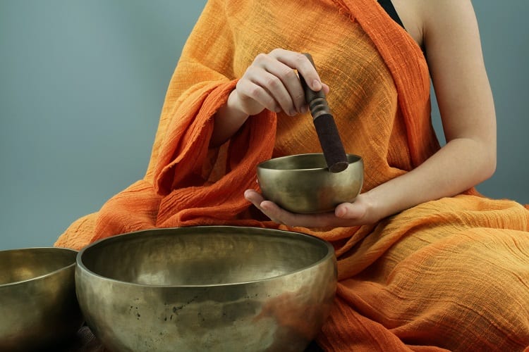 mulher com sinos tibetanos para meditação
