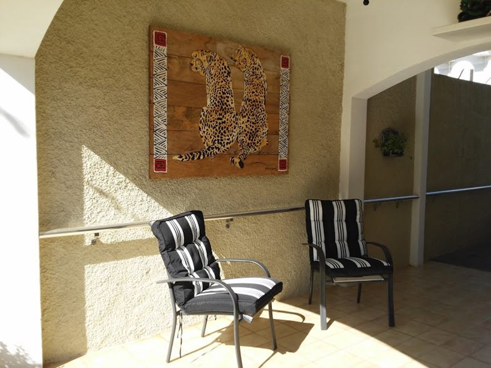 Ambiente com cadeiras e quadro de onças. Ambiente com duas cadeiras.