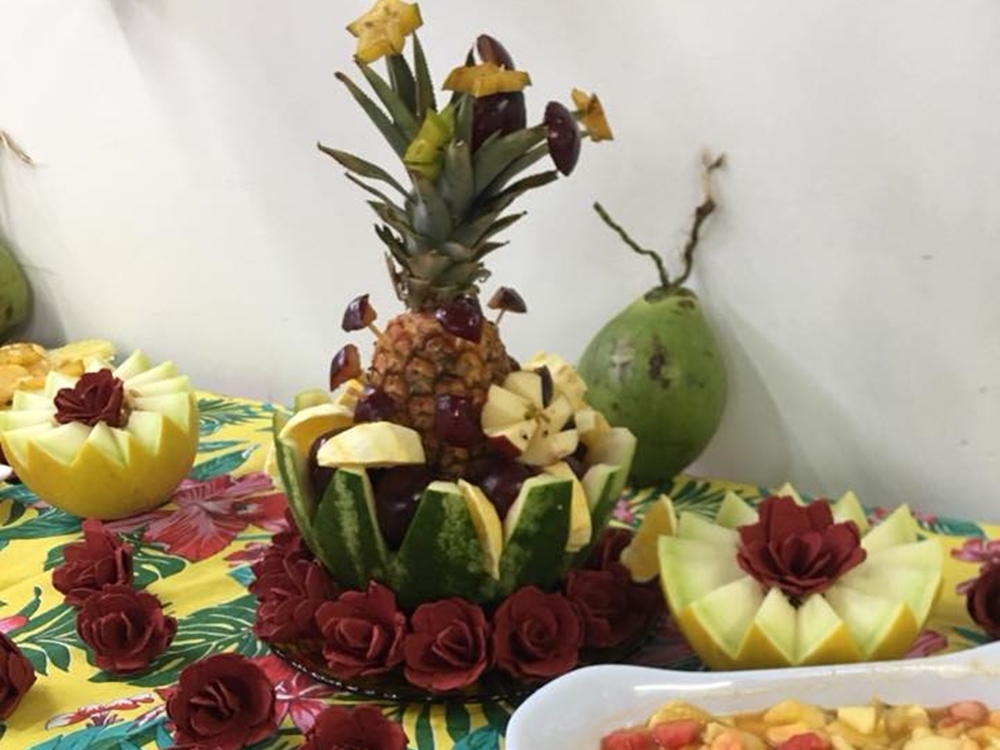 Frutas decoradas em asilo, com rosas em cima de mesa. Frutas decoradas em asilo