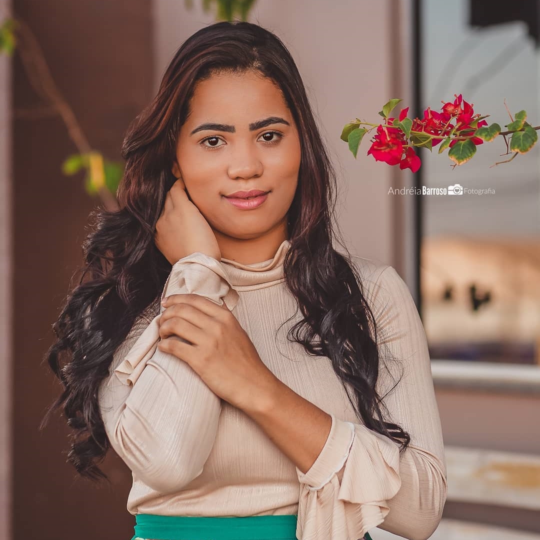 Stefhany Sousa com cachos no cabelo, blusa bege e saia verde. Foto de Stefhany Sousa