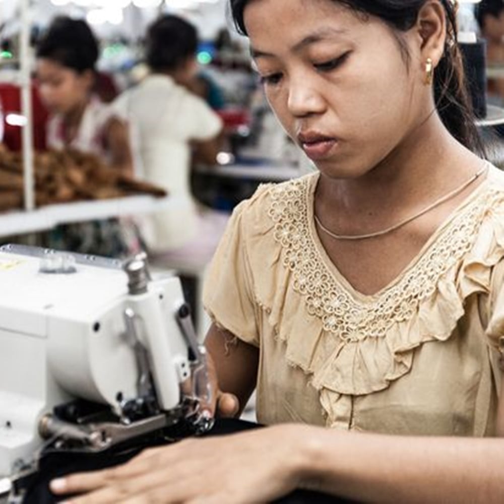 Mulher trabalhando em produção de roupas.