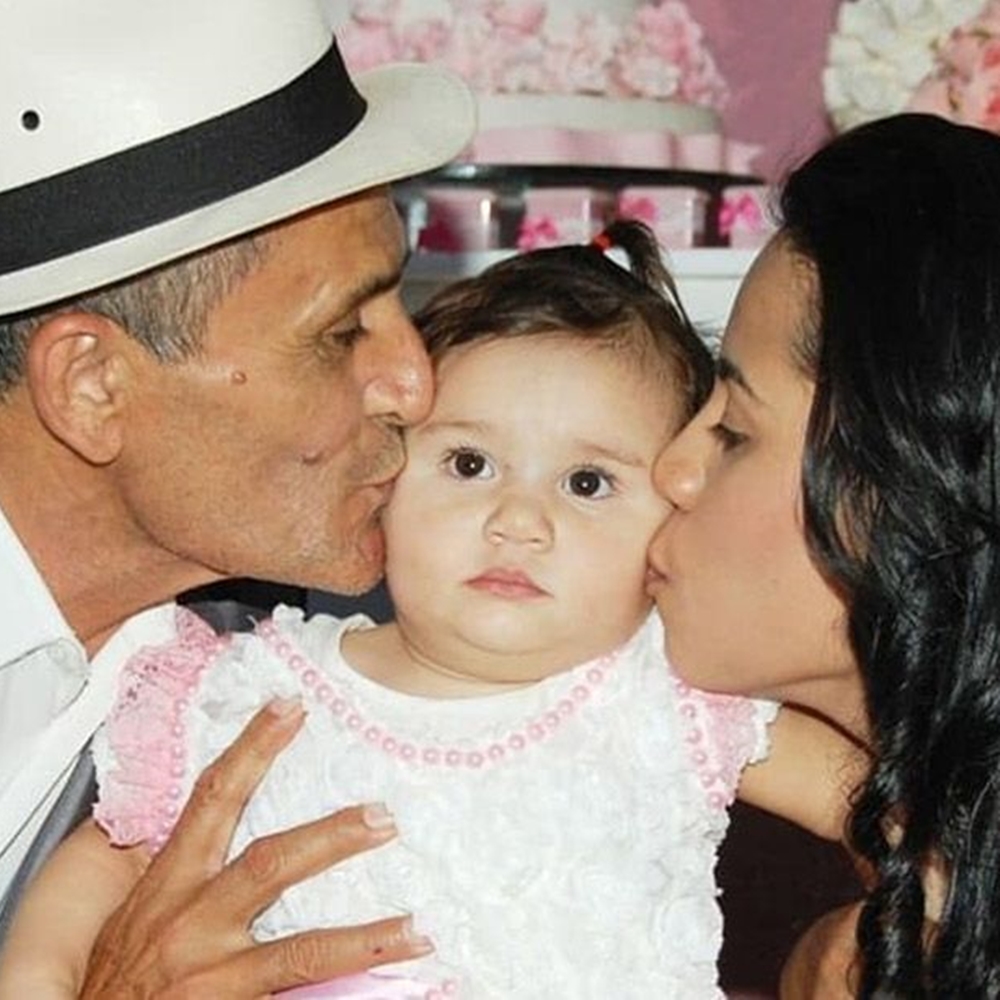Mãe e pai beijando rosto da filha. Stefhany Absoluta e Ricardo beijando rosto da filha.