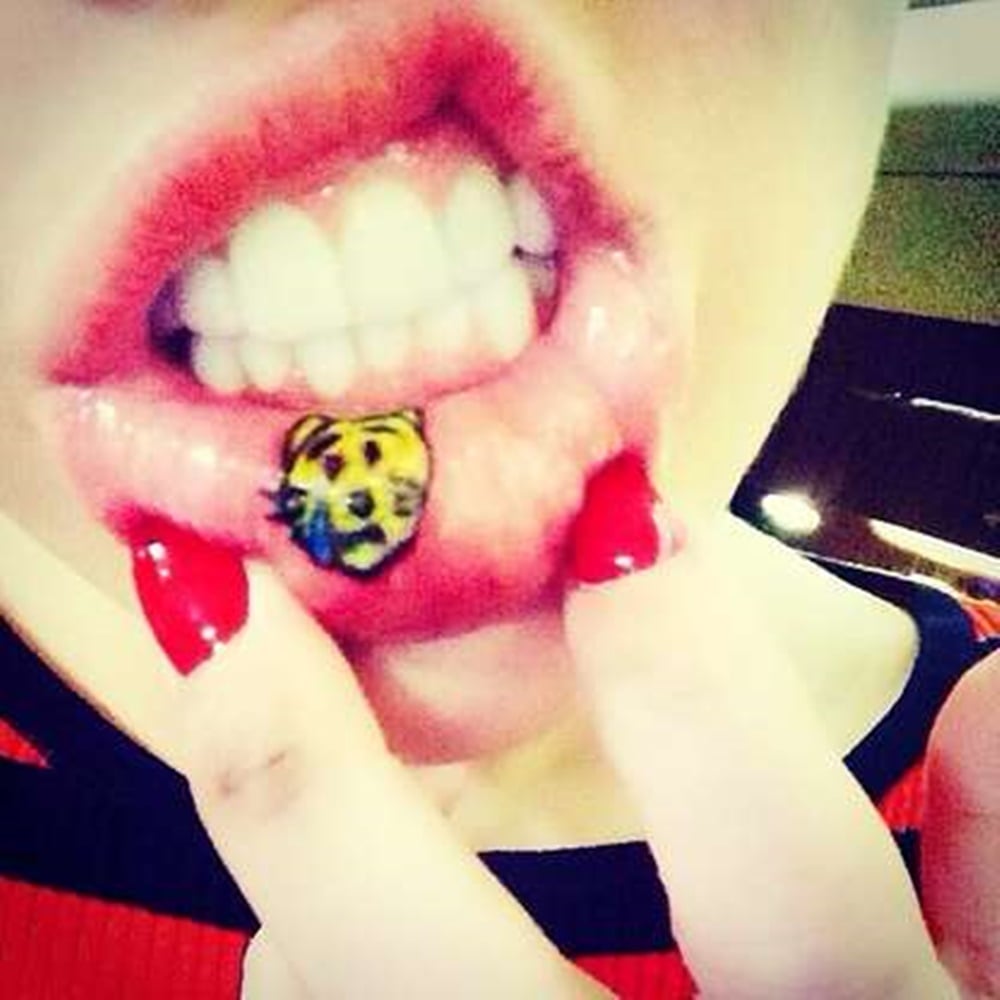 Tatuagem de emoji na boca de Miley Cyrus.