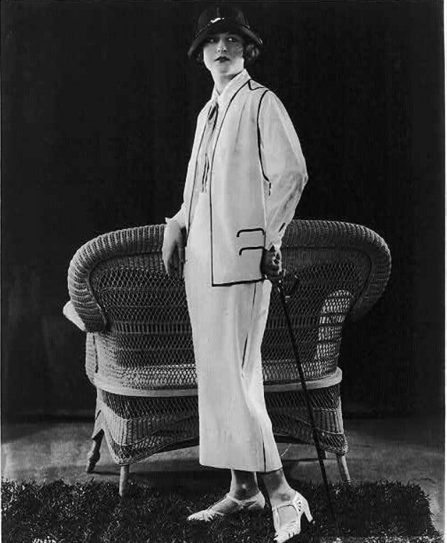 Mulher posando com um modelo de roupa branco e chapéu, em 1924. Look da Moda e Cidadania nos anos 20 e 30. 
