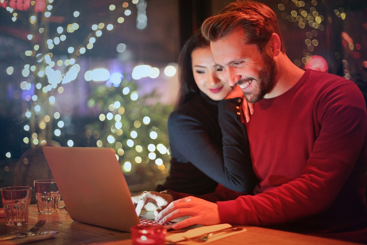 casal em frente a um computador procurando ofertas para economizar na Black Friday
