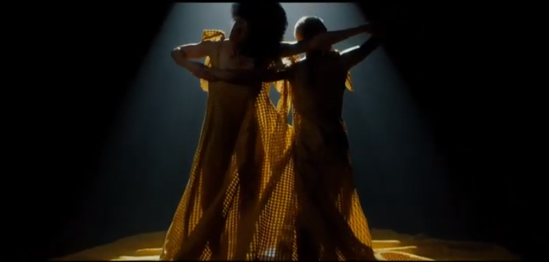 Duas modelos dançando com vestidos telados amarelo