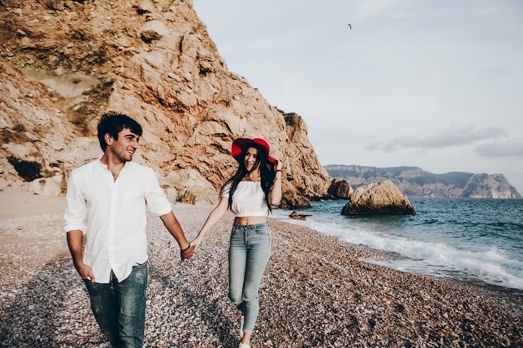 casal andando de mãos dadas na praia, frases românticas
