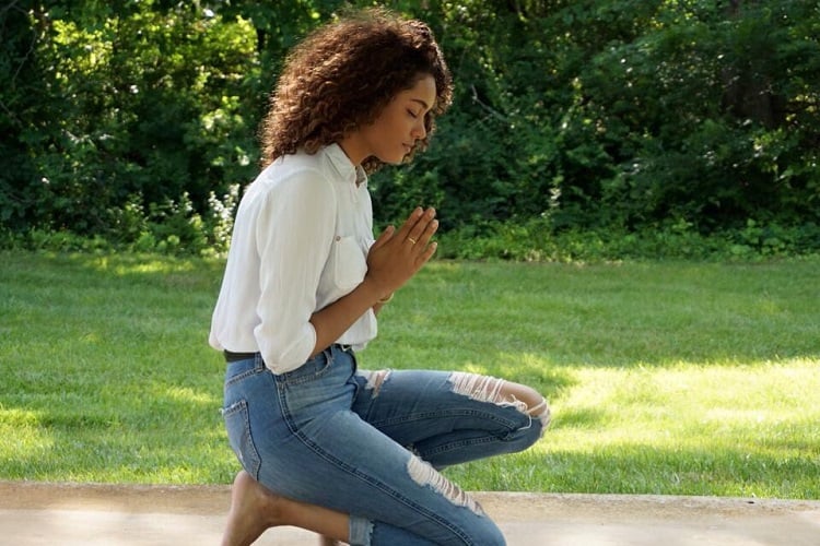 Menina orando de joelhos