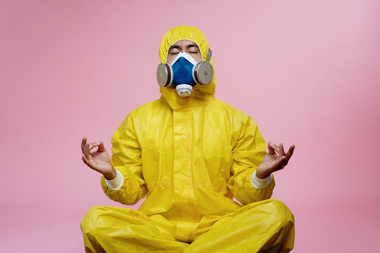 homem fazendo meditação com roupa protetora contra COVID-19