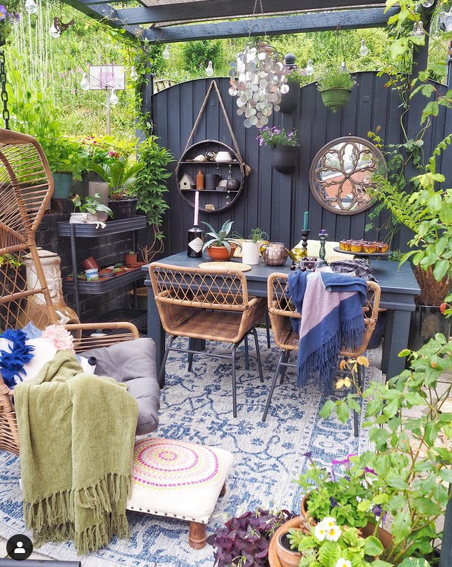 Garajem transformada em jardim residencial charmoso com mesa para chá e cadeira de leitura Jardim residencial