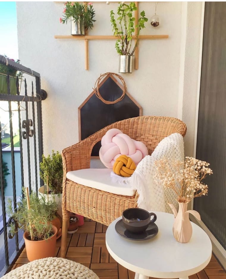Ambiente conchegante decorado. Varanda com poltrona e mesa.