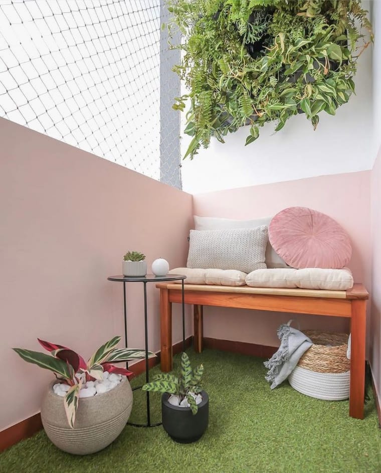 Ambiente com jardim vertical e vasos de plantas. Chão verde
