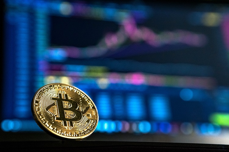 moeda de BitCoin com cotação de investimento ao fundo