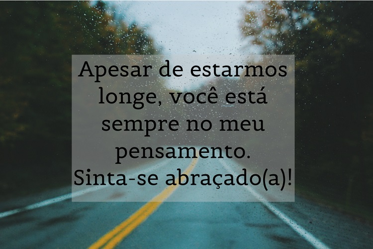 Foto de para-brisa em estrada na chuva e frase: Apesar de estarmos longe, você está sempre no meu pensamento. Sinta-se abraçado(a)!