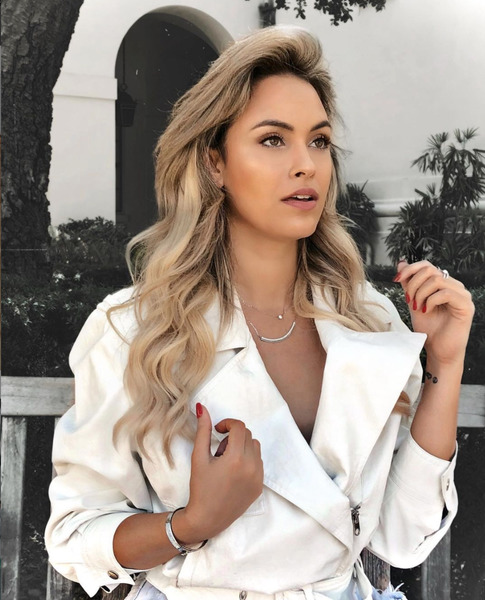 Sarah Andrade está vestida com um casaco elegante na cor branca.