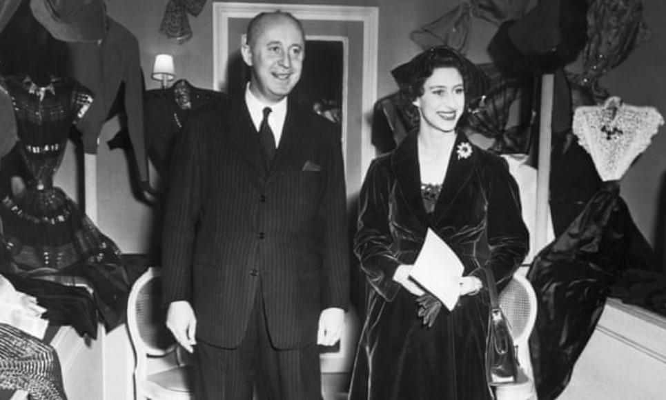Foto em preto e branco de Christian Dior com a Princesa Margaret durante a sua visita à Mansão Dior em Paris, em 1951. Christian Dior com a Princesa Margaret durante a sua visita à Mansão Dior em Paris, em 1951.