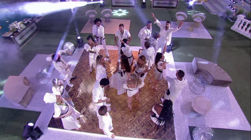 Na foto, aparecem os participantes na pista de dança em uma festa do BBB 21. Eles estão vestidos de branco.