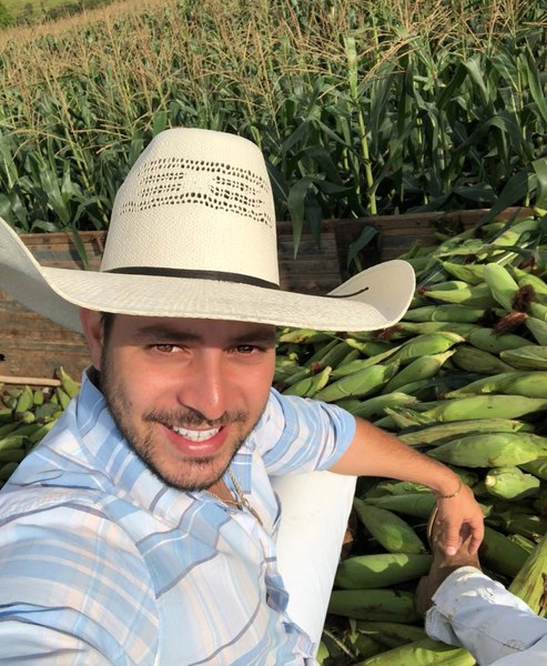 Caio do BBB 21 posa para selfie. Ele está trabalhando em sua colheita de milho.