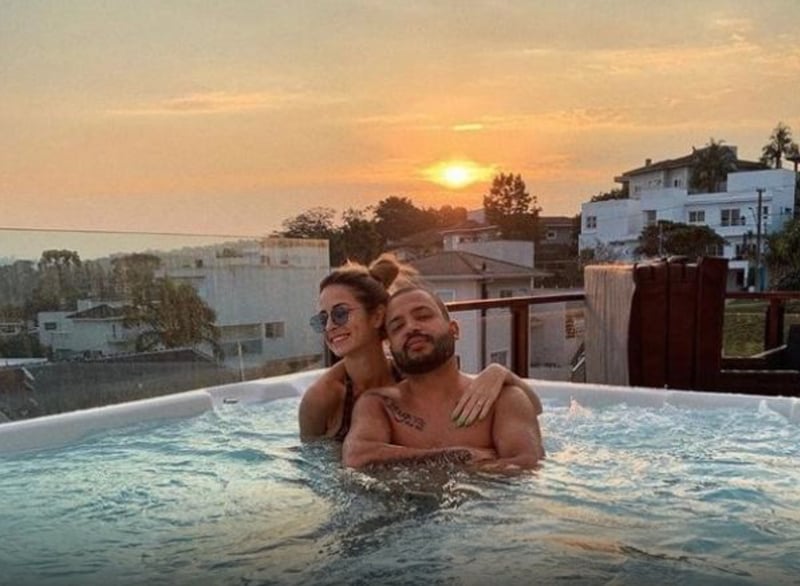 Na foto, aparece Projota e esposa em piscina