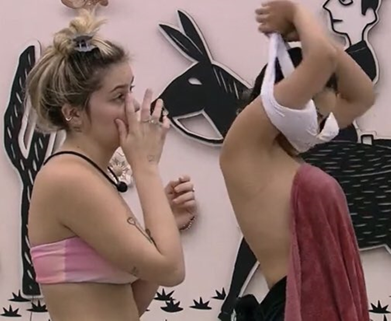 Juliette deixa toalha cair e mostra seios.