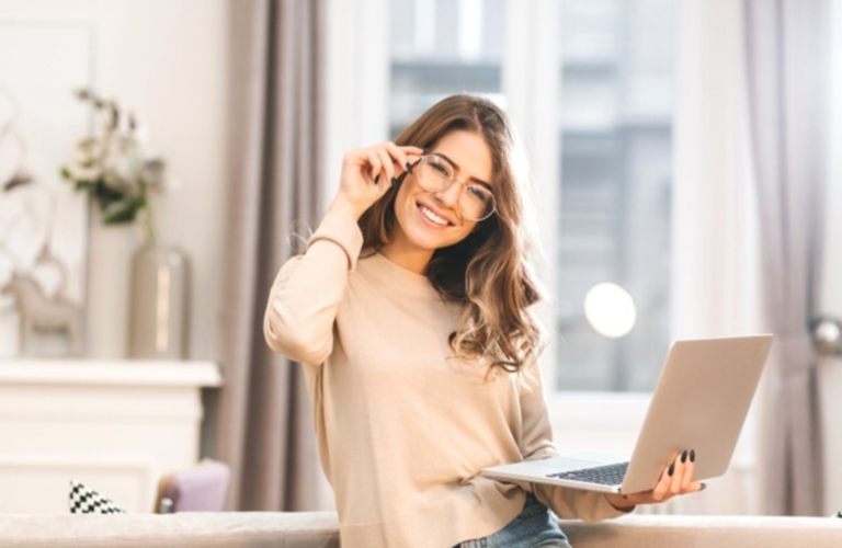 Imagem de garota empreendedora sorrindo segurando um notebook.