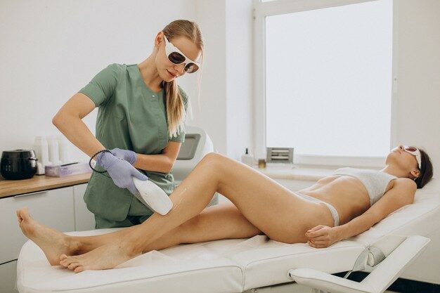 esteticista aplicando depilação a laser em perna de cliente