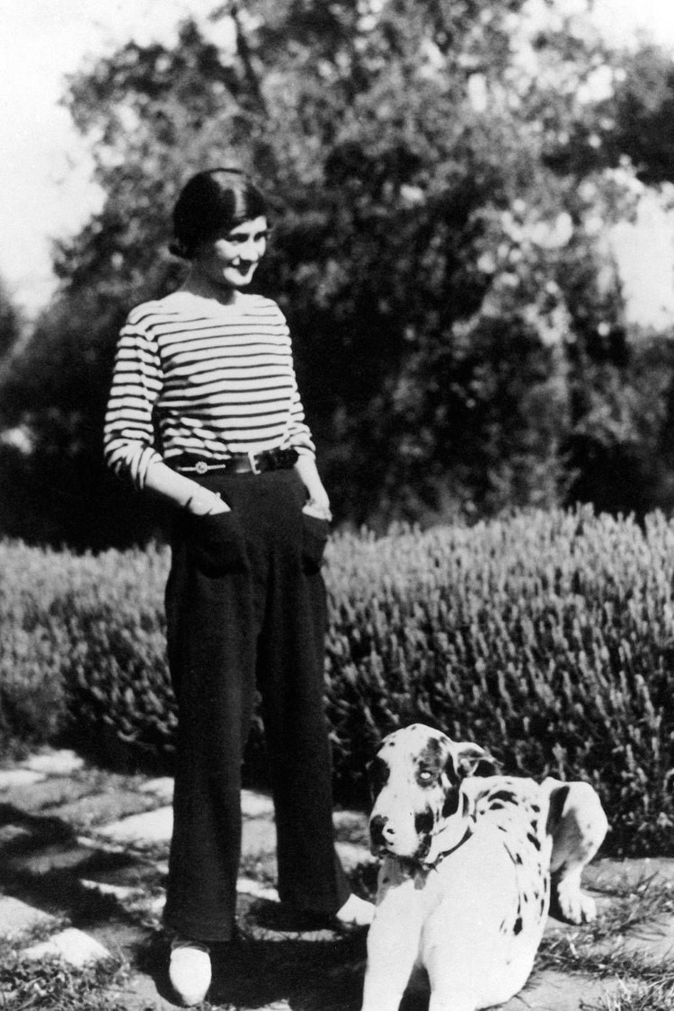 Coco Chanel com calça preta e blusa listrada- estampa de listras estampa de listras