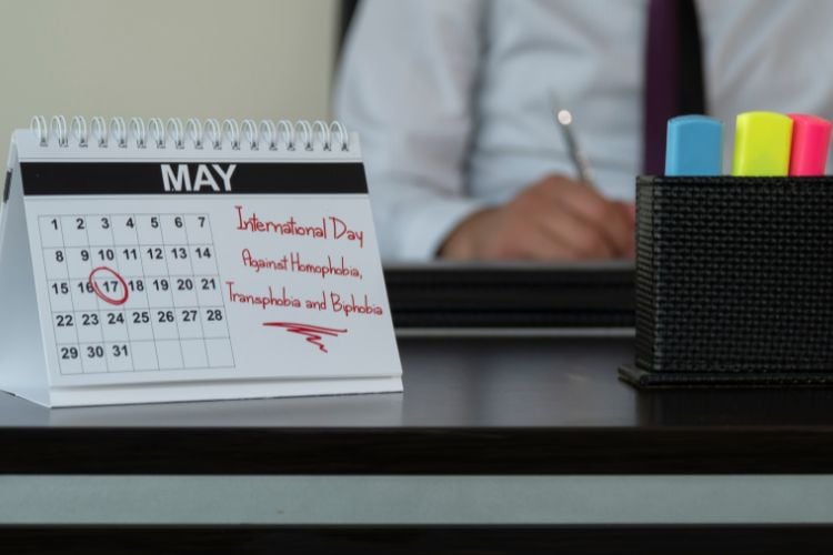 Homem de camisa branca escrevendo, com um calendário marcado 17 de maio ao lado