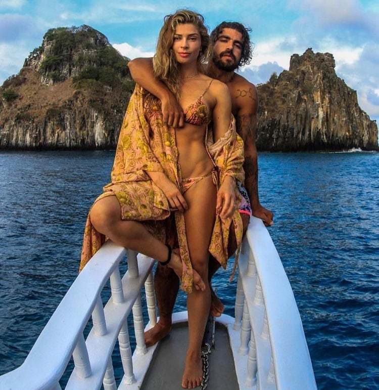 Grazi Massafera e Caio Castro posam em um barco, com roupas de praia, em Fernando de Noronha