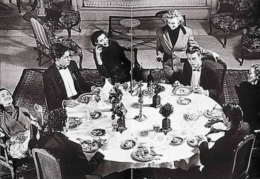 Foto em preto e branco de várias pessoas ao redor de uma mesa redonda na Sala de Importados da Daslu.