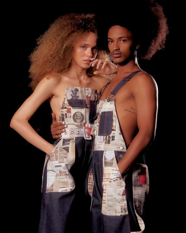 Um casal de modelos usam um macacão jeans com detalhes coloridos.