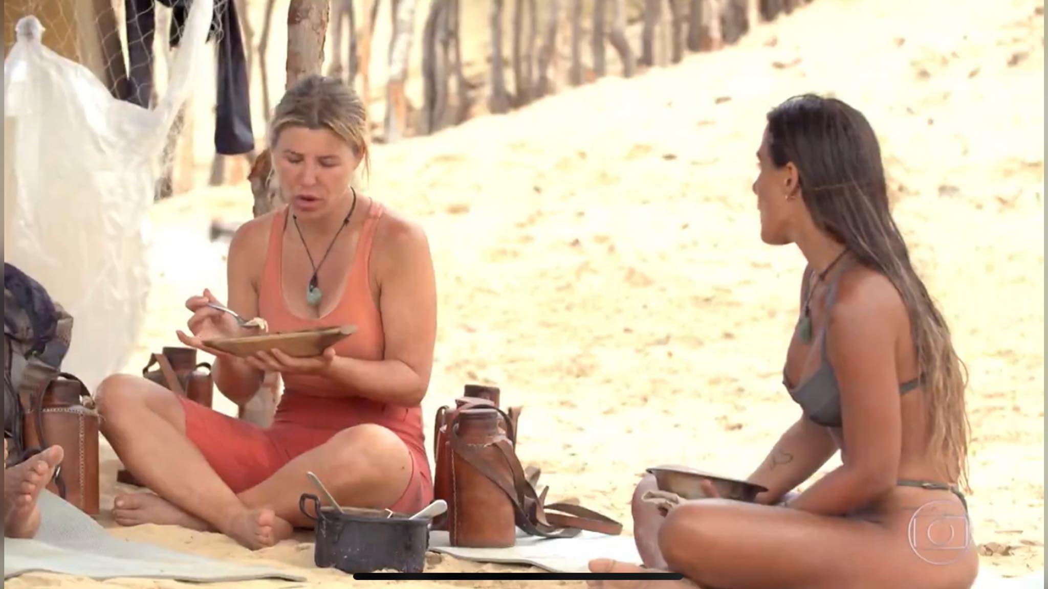 Carol Peixinho ouve as fofocas de Íris sobre a tribo Carcará (imagem: reprodução/ Globo) Carol Peixinho ouve as fofocas de Íris sobre a tribo Carcará (imagem: reprodução/ Globo)