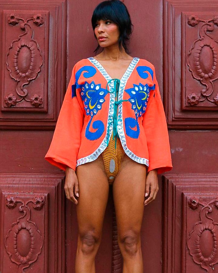 A modelo Suyane Moreira com uma jaqueta salmão e axul por cima de um maiô amarelo