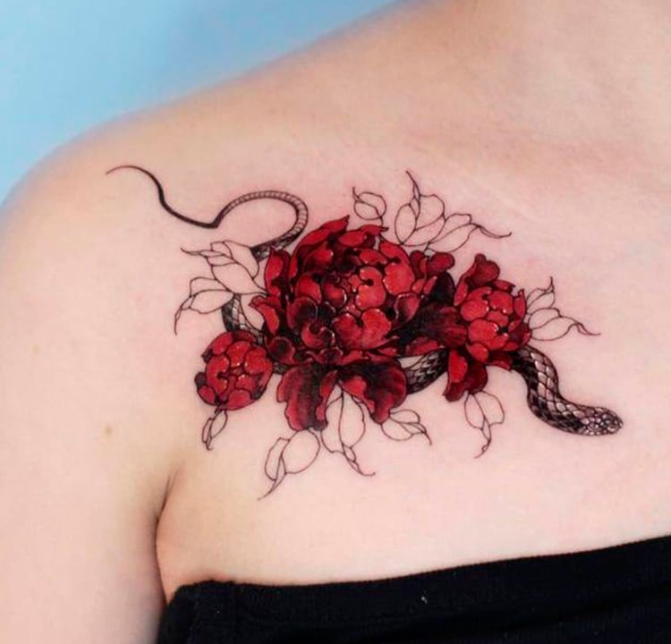 A foto de uma tatuagem de uma cobra cercada de flores vermelhas.