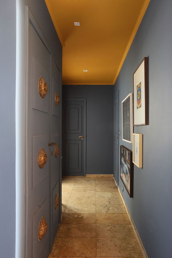 Hall de entrada. Teto amarelo e paredes cinzas.