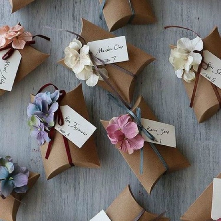 Caixinhas de papelão com laço de fita e orquídeas artificiais
