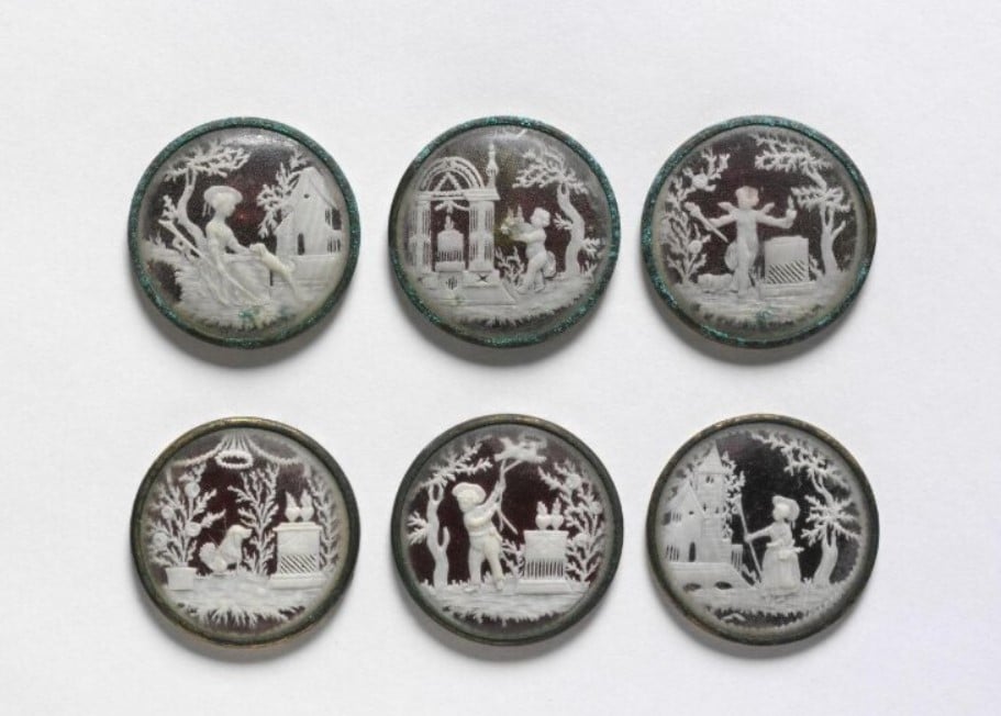 Conjunto de seis botões feito em marfim talhado com vidro e metal com cenas de pastores e pastagens 