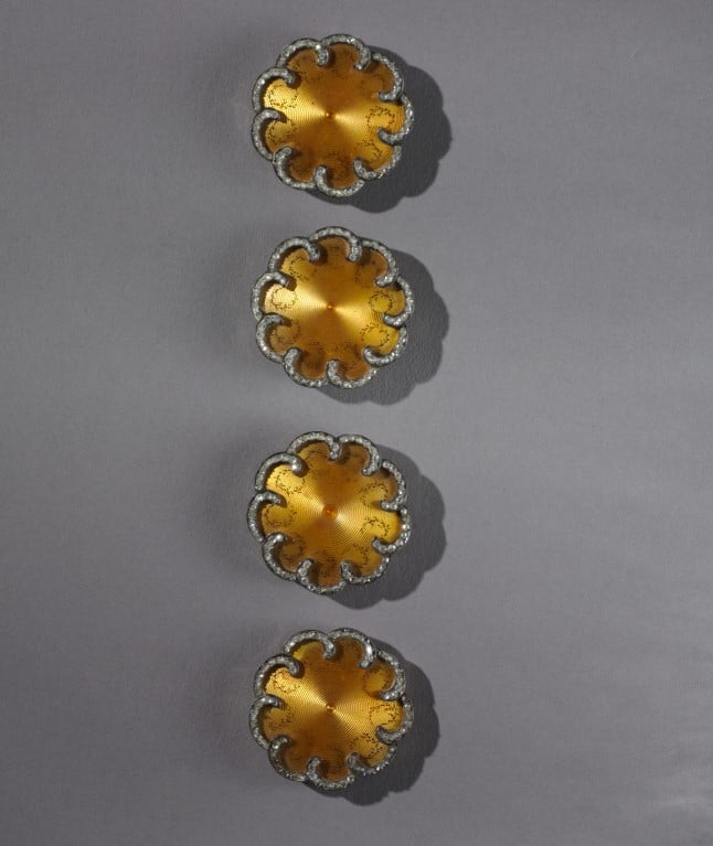 Foto de 4 botões douradosde Peter Carl Fabergé em forma de flor em fundo cinza