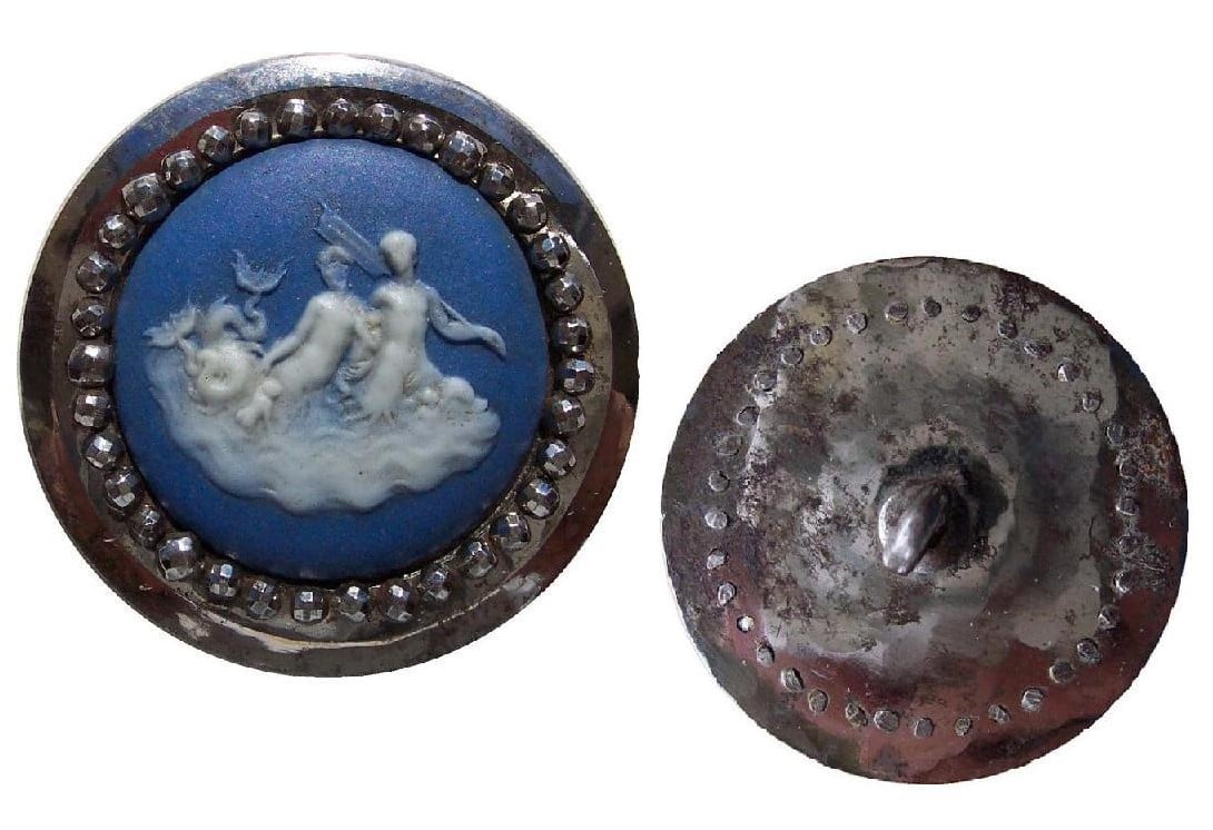 Botão de prata adornado com cerâmica azul e branca com a representação de sereias em fundo branco