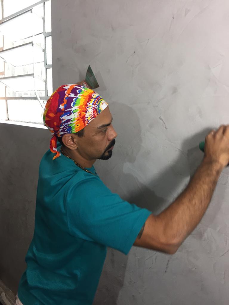 Homem pintando a parede.
