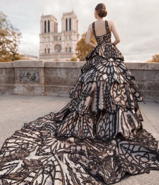 Modelo posando em Paris, de costas, com o vestido Catedral de Ivanildo Nunes, com Notre Dame ao fundo