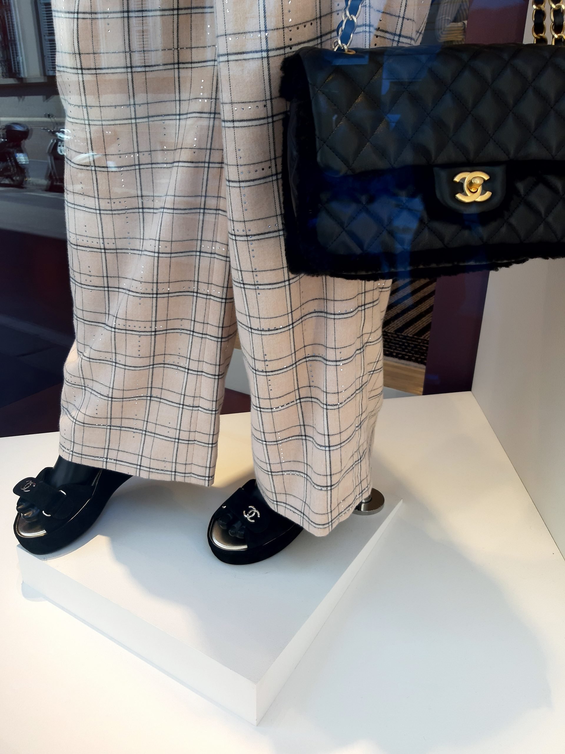 Detalhes de calça ampla e sandália confortável na vitrine da Chanel de Milão