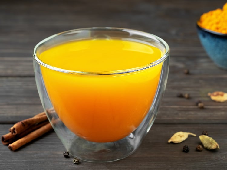 Foto de xícara de chá de vidro com líquido amarelo
