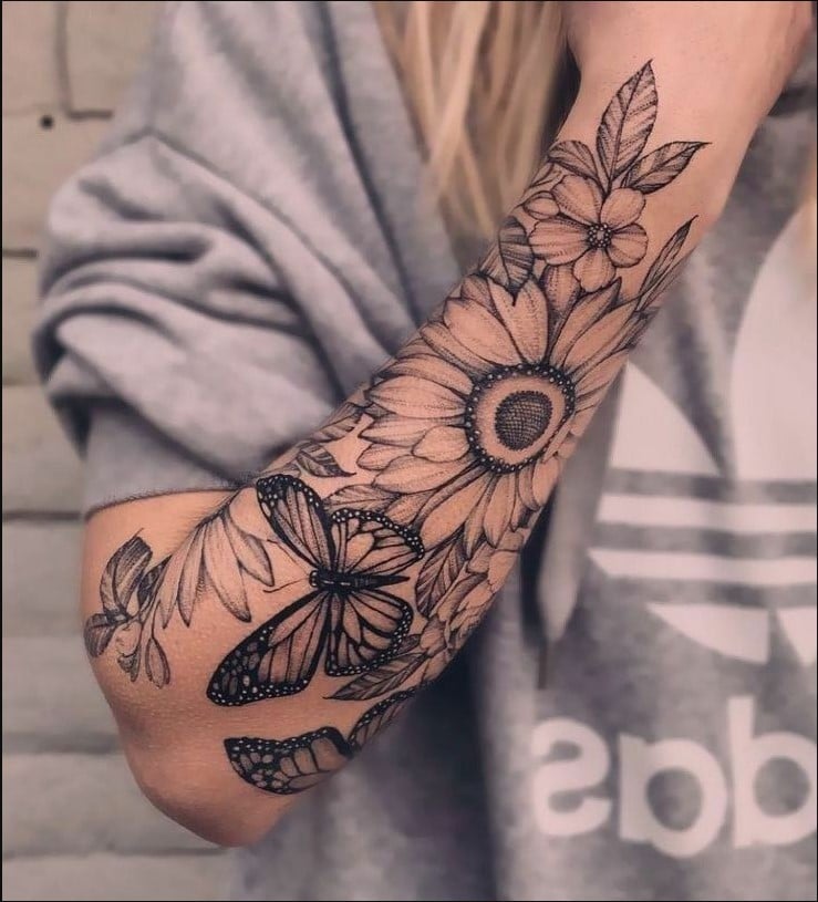 tatuagem feminina no braço flores e borboletas