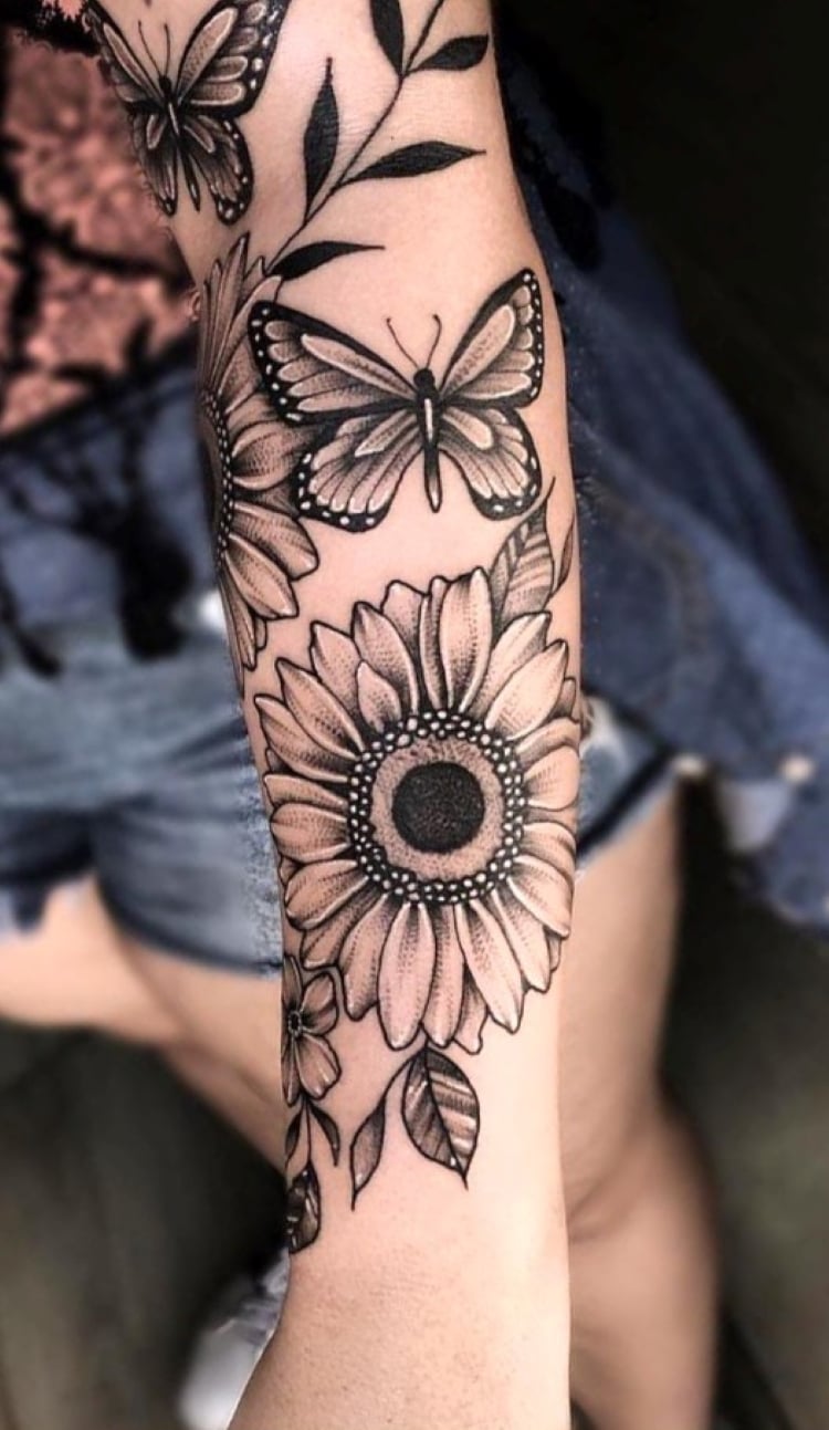tatuagem feminina no braço flores e borboletas