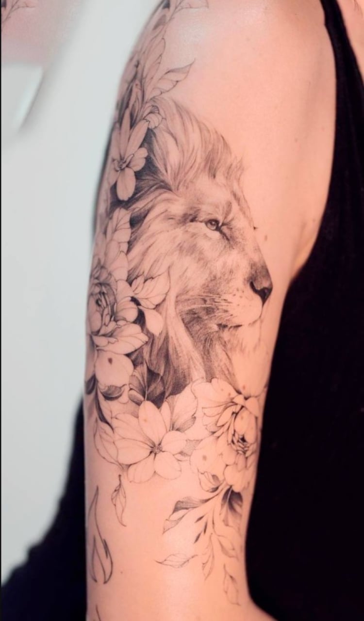 tatuagem feminina no braço/ leões e flores 