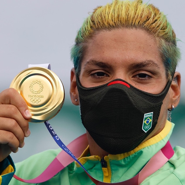 Foto de Ana Marcela segurando medalha de ouro.