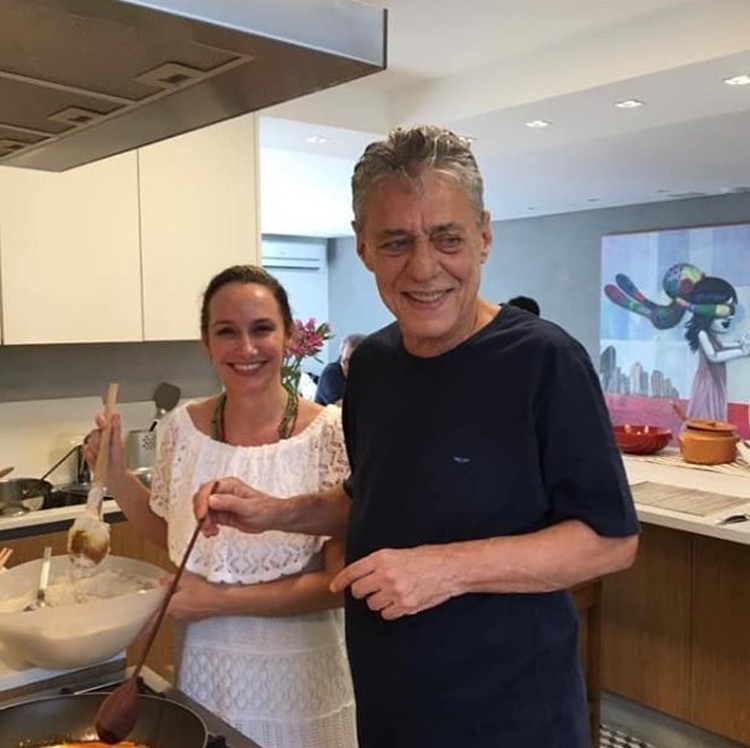 Foto do casal cozinhando.