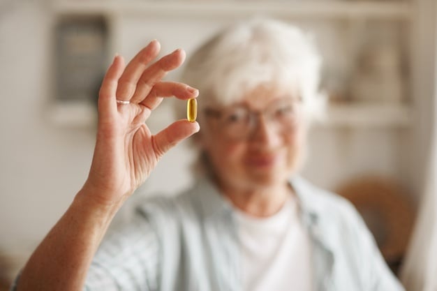 Mulher idosa segurando uma capsula de óleo de prímula